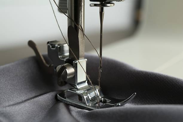 istock Sewing machine with gray fabric on light background, closeup 2216152498