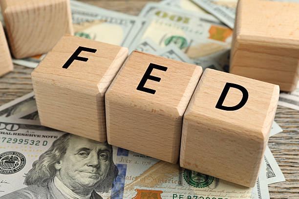 istock Wooden cubes with letters Fed (Federal Reserve System) and dollar banknotes on table, closeup 2216152657