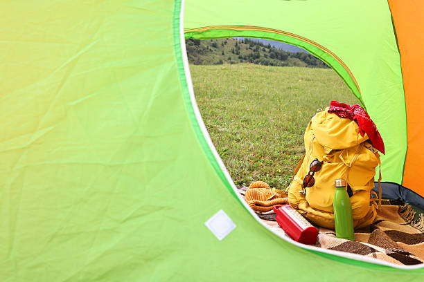 Night-time  shot of a glowing green tent set against a spectacular starry sky. The tent is positioned on rocky terrain, high up in the Dolomites mountain range of the European alps in Italy. Above, the sky is filled with countless stars, including a visible section of the Milky Way. Dolomites mountains of South Tyrol in the European alps, Trentino-Alto Adige, Italy, Europe.
