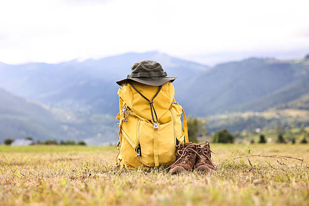istock Backpack, hat and trekking shoes on grass outdoors 2216153041