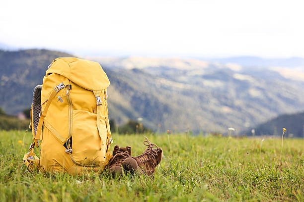 istock Backpack and trekking shoes on green grass outdoors, space for text 2216153042