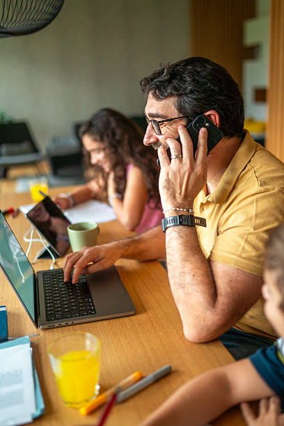 hispanic father balances work and family in cozy home - evden çalışma stok fotoğraflar ve resimler