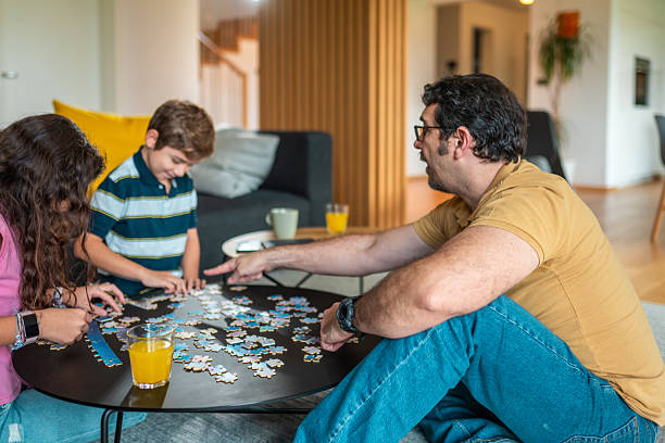 istock Hispanic Father and Children Engaging in Puzzle Building Activity 2216163452