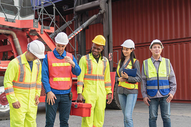 istock Relaxing engineer and foreman worker team in industry containers yard, Diverse team of workers at shipping container cargo 2216172187