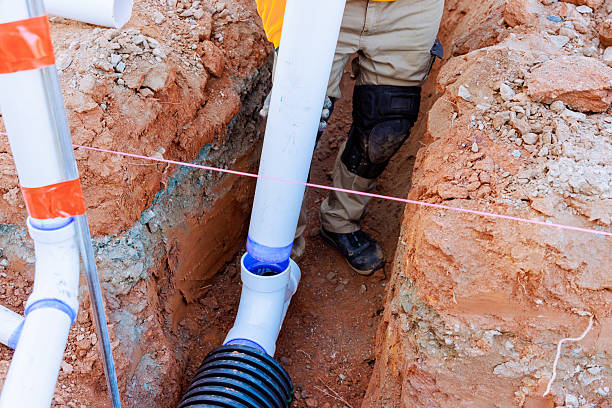 istock Workers install drainage pipes in construction site trench during daylight hours 2216176240