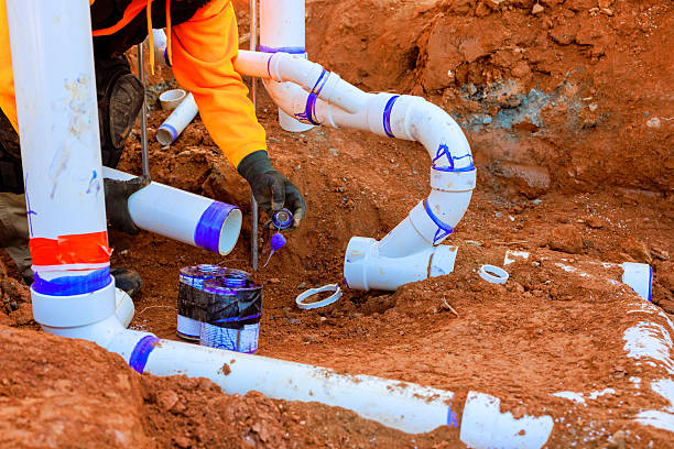 istock Construction worker installs plumbing in trench at construction site during works day 2216176251