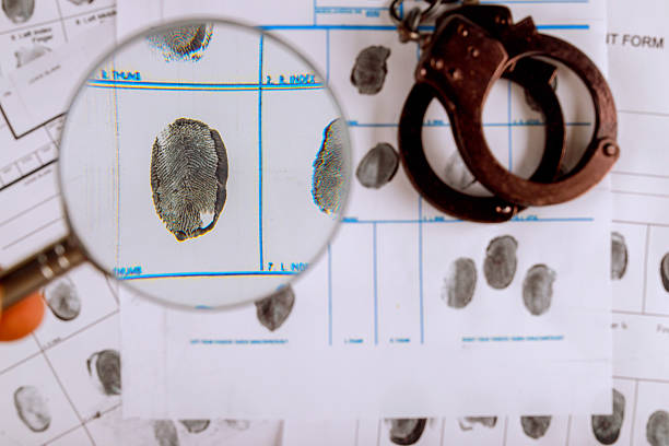 istock Examining fingerprints on crime scene evidence with handcuffs paperwork 2216176467