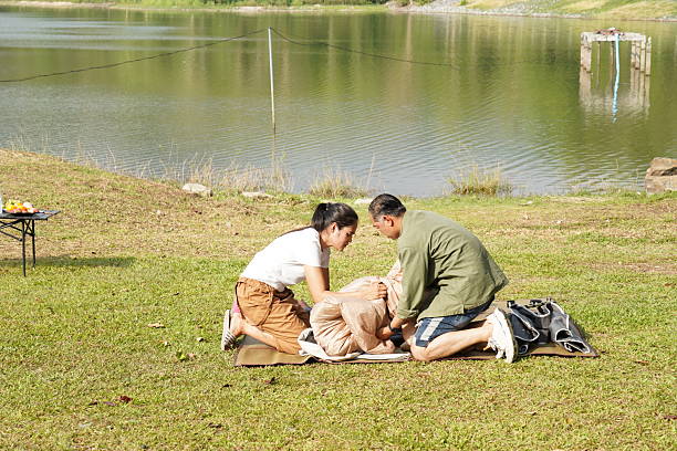 istock Couple Setting Up a Tent by the Lakeside 2216182150