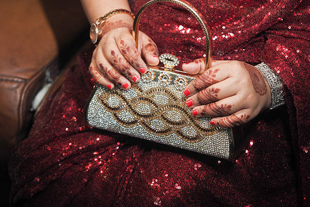 istock Elegant hands adorned with henna holding a sparkling clutch 2216183697