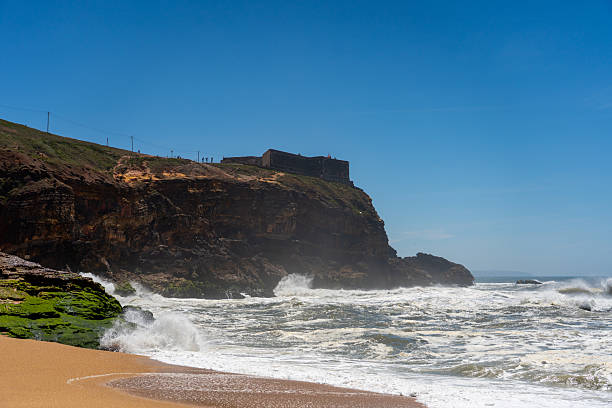 istock Lighthouse on cliff above turbulent sea 2216184222