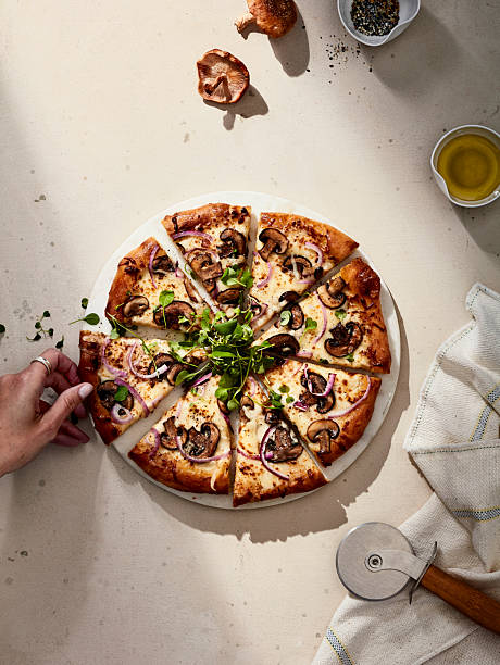 istock Sliced mushroom pizza with herbs on light stone background 2216188317