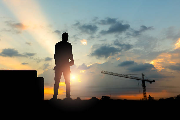 istock Silhouette of Engineer on building site, construction site at sunset in evening time 2216188359