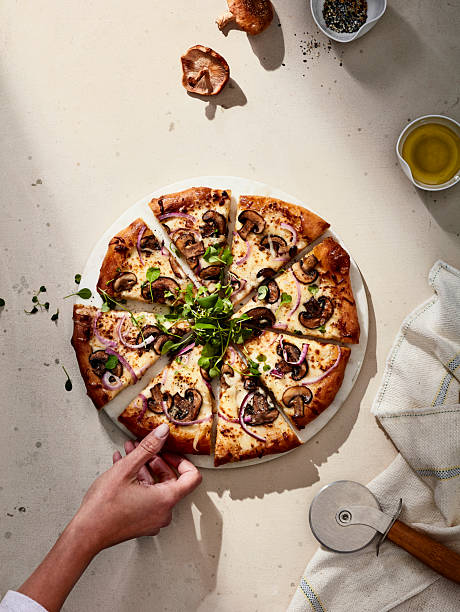 istock Sliced mushroom pizza with herbs on light stone background 2216188371