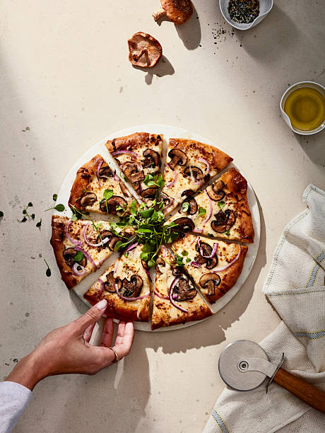 istock Sliced mushroom pizza with herbs on light stone background 2216188441