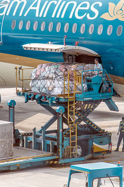 HANOI, VIETNAM, APR 19 2019, A manipulation with shipments in air transport. Unloading cargo from an aircraft using a lift platform on the Noi Bai International Airport.