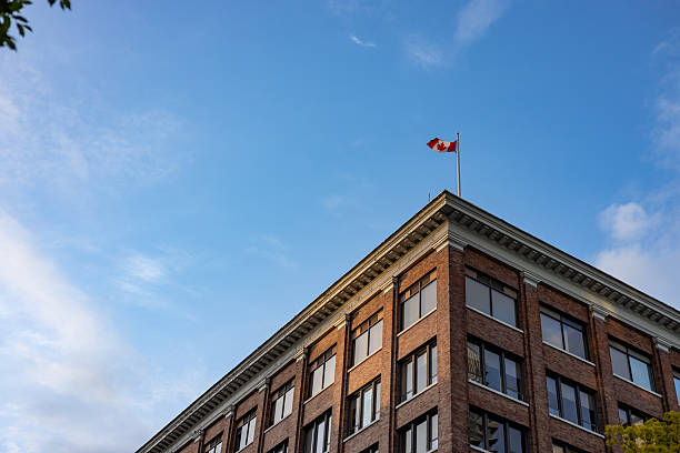 Canada flag on top of a classic building seen from below