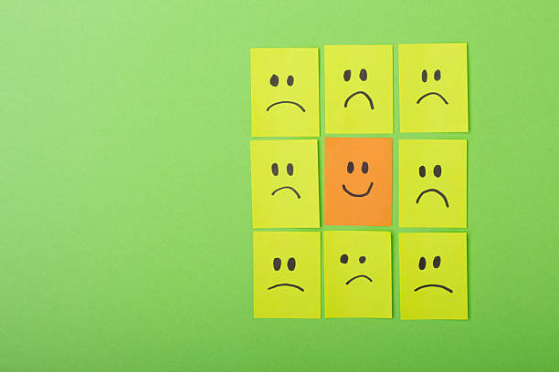 istock Unique Smiley Face Among Sad Faces on Colorful Sticky Notes 2216193548