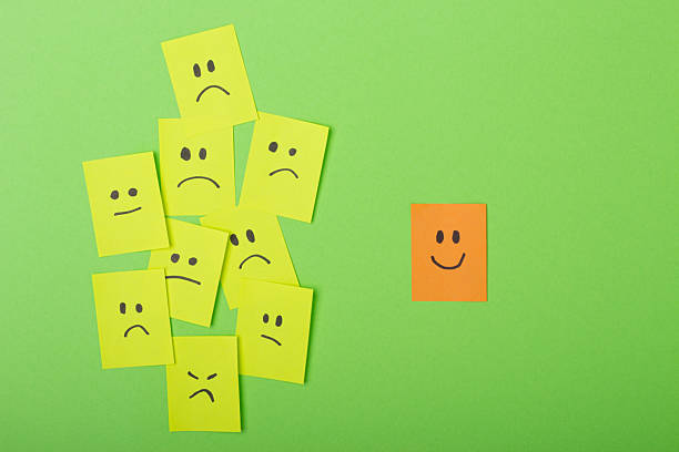 istock Positive attitude concept with Colorful Post-Its on Green Surface multiple faces and one standing out with a smile. 2216193551