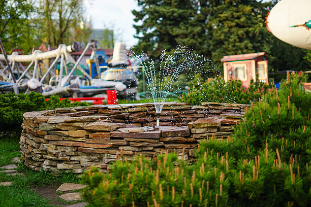 A stone fountain in a garden setting, water feature surrounded by greenery