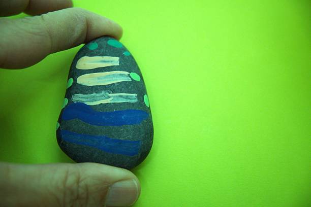 istock Painted pebble with green background 2216196051