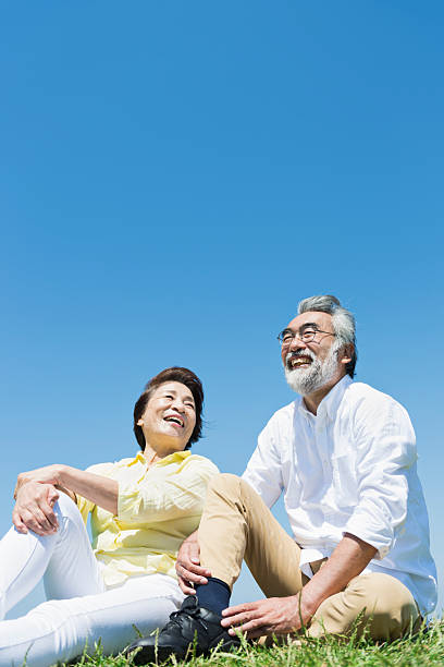 Senior couple in a grassy field under a blue sky