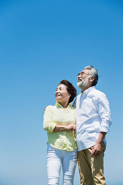 Senior couple in a grassy field under a blue sky