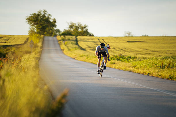 istock Professional cyclist sprinting on the road at sunset. 2216201769