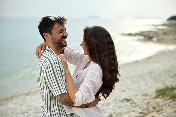 istock Cheerful couple in love talking on the beach. 2216201891