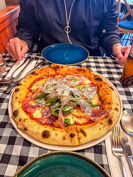 istock Delicious pizza topped with fresh ingredients served on a checkered tablecloth 2216202612