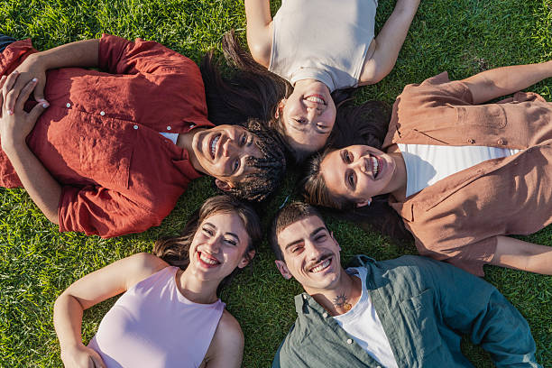 istock Happy multicultural friends lying on grass in a circle 2216210570