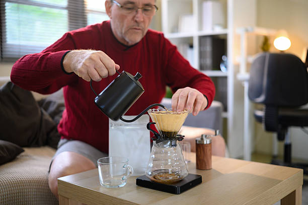 istock Senior man making fresh pour over coffee at home using a gooseneck kettle and glass dripper 2216212669