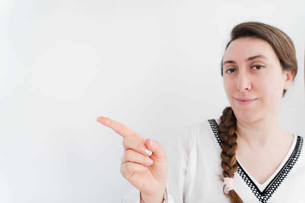 woman pointing with index finger to the left side on white background