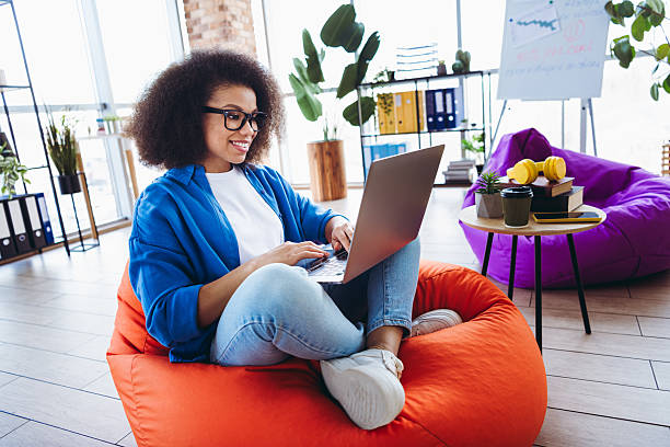 istock Confident Young Businesswoman Working Remotely and Smiling in a Modern Workspace with a Relaxed Ambience 2216216434