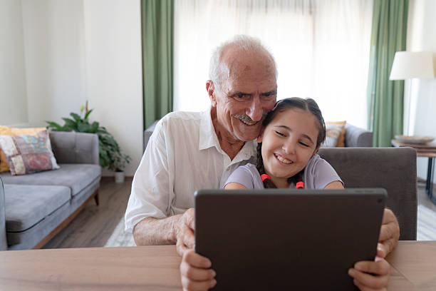 istock Grandfather and granddaughter using tablet 2216217198