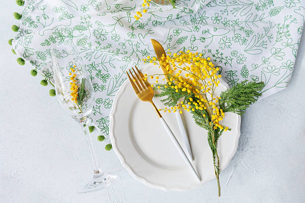 istock Elegant spring table decor with mimosa bouquet and gold utensils 2216218652