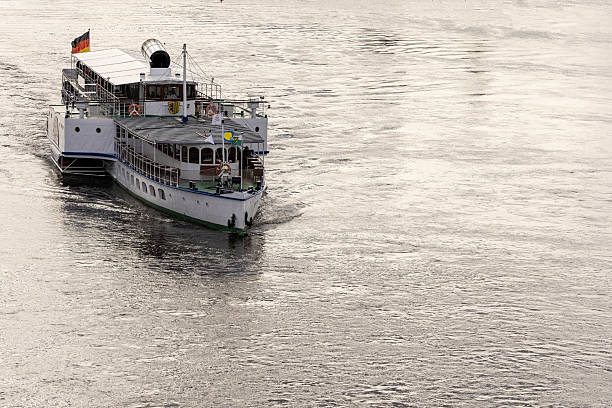 Budapest, Hungary, May 2025Old fashioned style paddle steamer river craft with passengers enjoying a tour of the River Danube on an overcast day. There are lots of tourists on the deck looking out across the Danube.