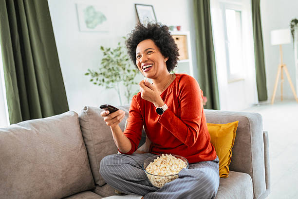 istock Happy Woman Watching Television with Popcorn on the Couch 2216228579