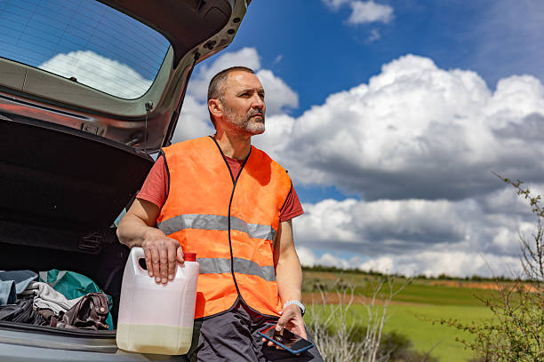 Worried road worker waiting for help with empty fuel tank