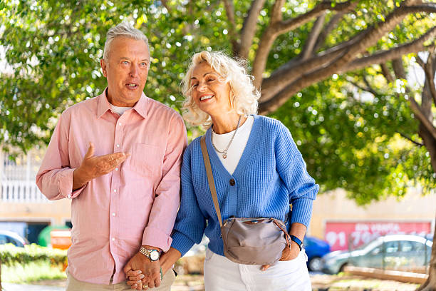 istock Happy retired couple walking and talking in a park 2216230074
