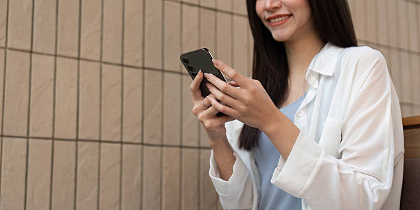 istock Connection and Engagement. A young woman smiling while texting on her smartphone, embracing modern communication in a stylish cafe. 2216230802