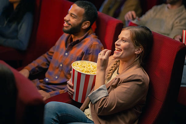 istock Young Multiracial Couple Enjoying Popcorn in a Cozy Cinema Setting 2216230839