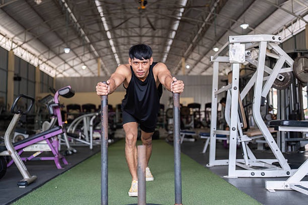 istock Pushing Limits: Young Man Training with Weighted Sled at Gym 2216233873