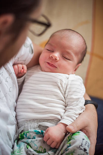 istock Peaceful Newborn Sleeping in Parent's Arms 2216235666