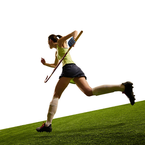 Low angle view of female hockey player pushes forward uphill symbolizing challenge determination and athletic progress. Concept of sport events, competition, championship, game, movements.