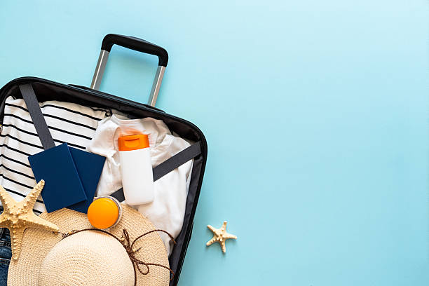 istock Open Suitcase with summer cloth, shoes and accessories on blue background. 2216239297