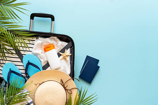 istock Open Suitcase with summer cloth, shoes and accessories on blue background. 2216239299