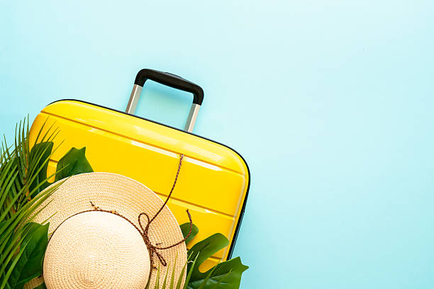istock Suitcase, hat and flip flops on blue background. 2216239315