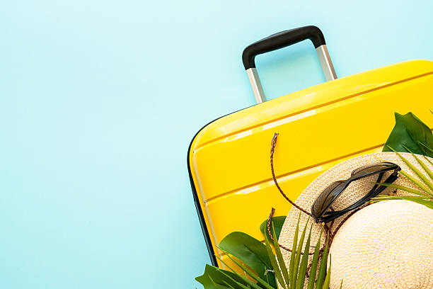 istock Suitcase, hat and flip flops on blue background. 2216239329