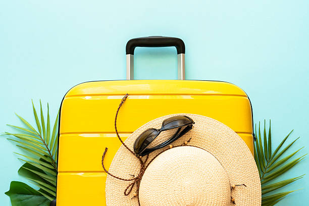 istock Suitcase, hat and sunglasses on blue background. 2216239331