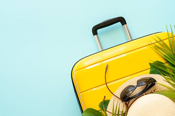 istock Suitcase, hat and sunglasses on blue background. 2216239368